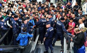 SALZBURGO (AUSTRIA) 5/09/2015. Policías forman un cordón frente a los cientos de refugiados que esperan la llegada de más trenes con dirección a Alemania en la estación de Salzburgo. EFE/Barbara Gindl